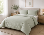 Sage green bamboo duvet cover set on a bed in a bright Scandinavian-style bedroom — Pebble & Loom