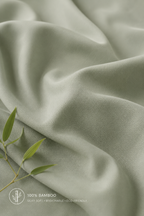 Close-up of sage bamboo duvet cover fabric showing a silky sateen weave and shiny finish.