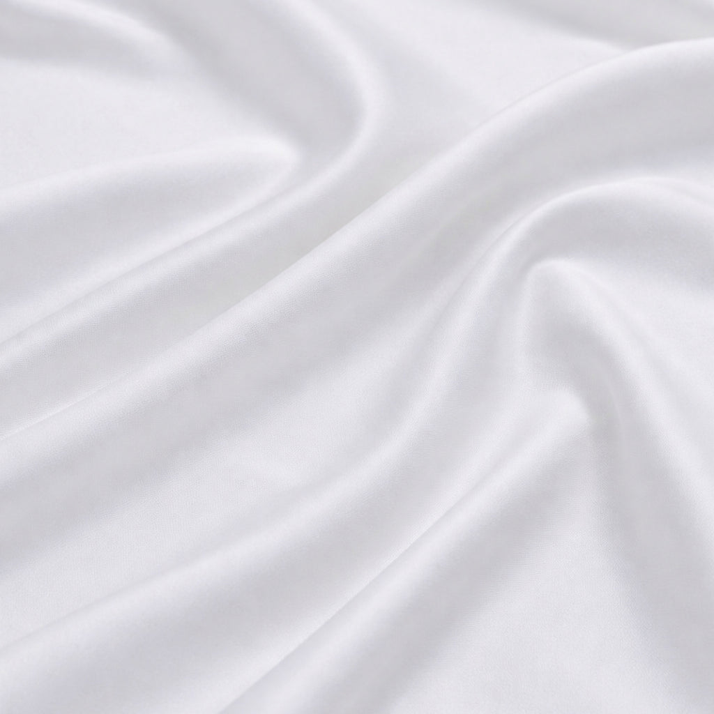 Close-up of silky white bamboo fabric with a soft sateen sheen, premium bamboo bed linen texture.