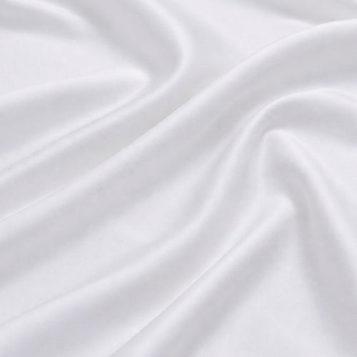 Close-up of silky white bamboo fabric with a soft sateen sheen, premium bamboo bed linen texture.