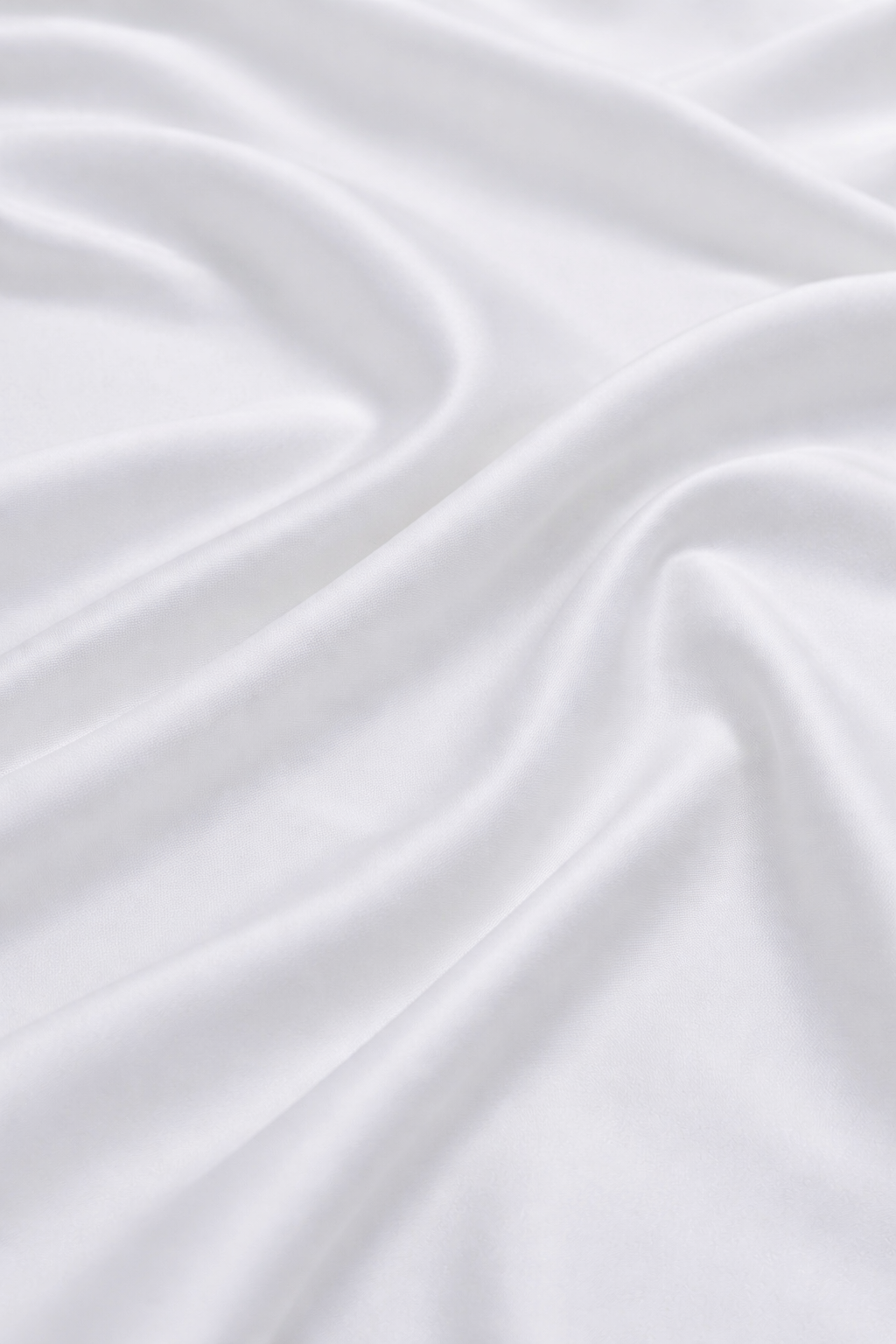 Close-up of silky white bamboo fabric with a soft sateen sheen, premium bamboo bed linen texture.